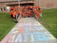 photo shows students and staff standing in front of Joseph H. Kerr School in Snow Lake. All students and staff are wearing their Orange Shirts 'Every Child Matters'.